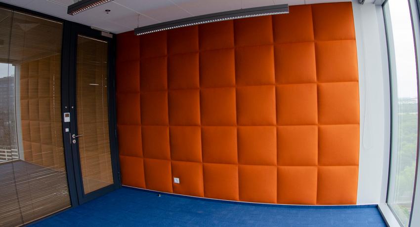 Ściana tapicerowana pikowaniem liniowym w biurze